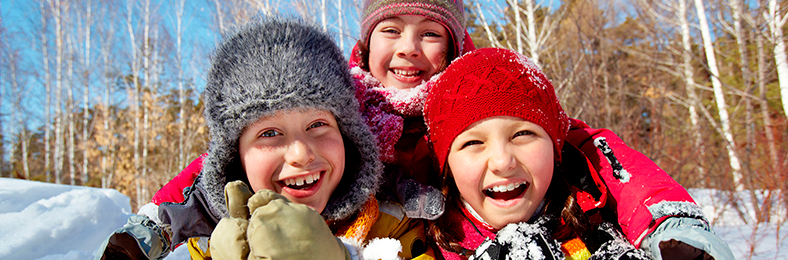 Lapset pitävät hauskaa ulkona talvella.