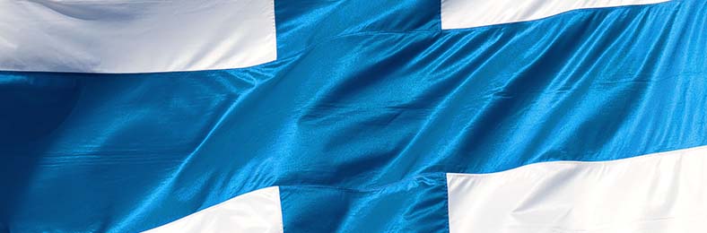 Lähikuva lipputangossa hulmuavasta Suomen lipusta