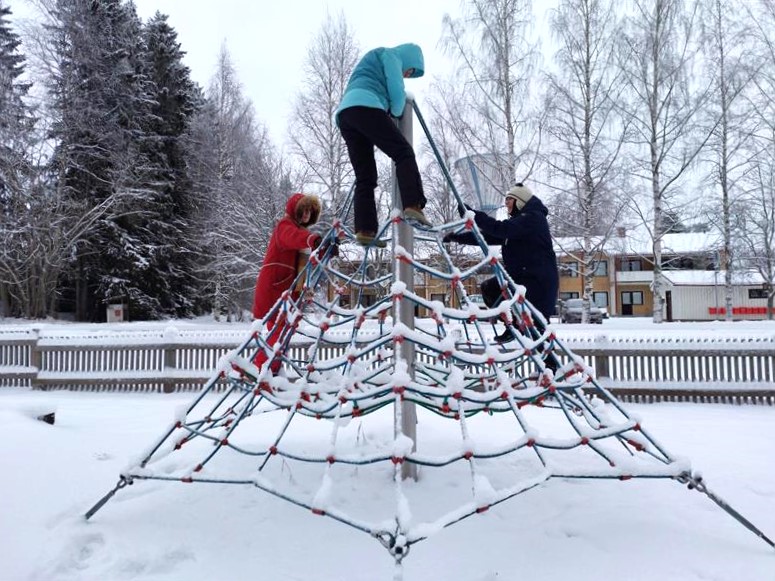 Liikkujat kiipeilevät leikkipuiston hämähäkinverkon näköisessä telineessä.